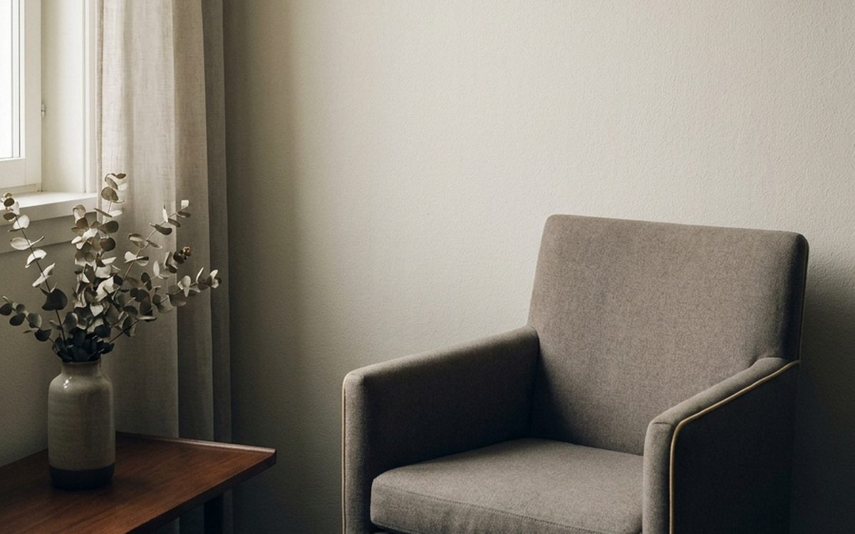 A quiet room with soft daylight through a window and an empty armchair